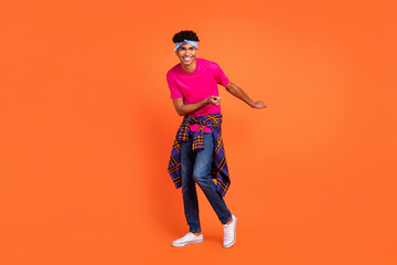 Fototapeta na wymiar Full length body size photo of happy young man dancing on weekend laughing in stylish clothes isolated on vivid orange color background