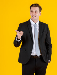 Portrait half body of handsome and executive look french businessman in black suit pointing finger to blank space in advertising pose. Successful and happy business man concept on yellow background
