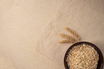oatmeal for breakfast on a linen background with wheat. copy space