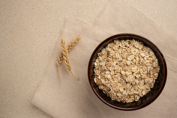oatmeal for breakfast on a linen background with wheat. copy space