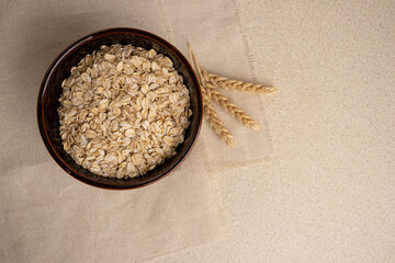 oatmeal for breakfast on a linen background with wheat. copy space