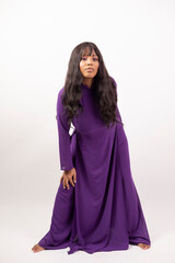 Beautiful African American Model in traditional Vietnamese purple au dai dress on a white studio background. Full length Asian Fashion