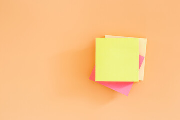 Stack empty sticky post note paper sheet on orange background. post it paper note.