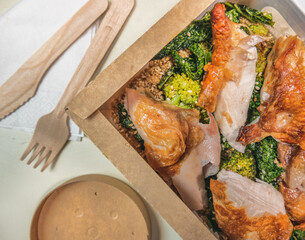 Organic chicken dish served with broccoli and sesame seeds in degradable packaging for delivery