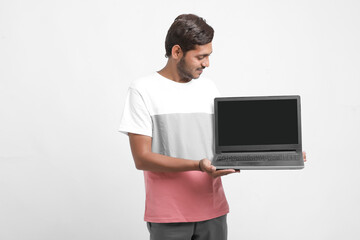 Indian college student showing laptop screen on white background.