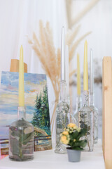 yellow and white candles with flowers and bottles