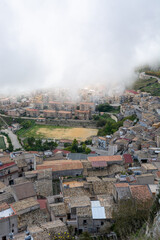 Caltabellota houses in the region Agrigento in Sicily, Italy with low hanging clouds. Little mediterranean mountain village.