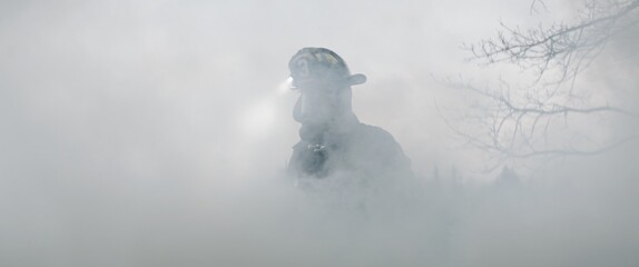 Hero shot portrait of American male firefighter in full gear standing in the smoke. Shot with 2x...
