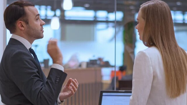 Art of communication. Business talks in action. The businessman and businesswoman communicate in the office. High quality 4k footage