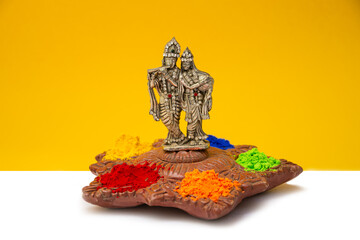 Radha Krishna with holi color powder yellow background