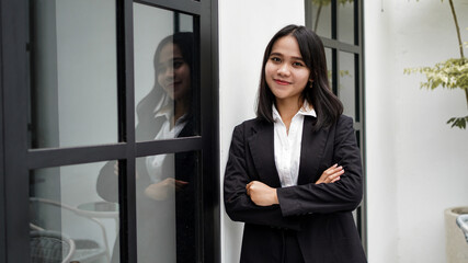 Asian business woman smiling and standing in front office