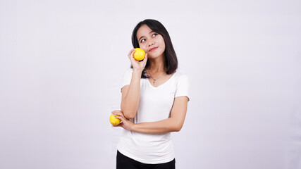 beautiful asian women thinking with a lemon isolated on white background