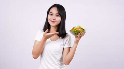 asian women pointing finger at a bowl of fresh mixed vegetables salad with isolated white background