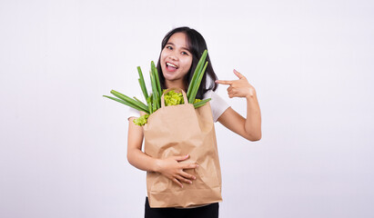 Fototapeta na wymiar Beautiful asian woman smiling with paper bag of fresh vegetables with isolated white background