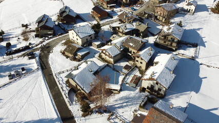 Fototapeta na wymiar Villaggio di montagna fotografato dall'alto con un drone durante l'inverno con la neve