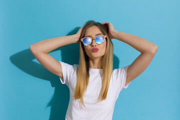 Young Blond Woman In White Shirt And Sunglasses Is  Sending A Kiss