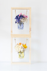 Dried flowers in glass container inside a frame