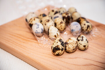 fresh quail eggs in a plastic box on a wooden board, quail eggs for a delicious Easter holiday in a tray, preparation for Easter, healthy dietary food, diet