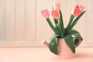 Easter vase with tulips on pink wooden table. Easter celebration concept. Soft focus