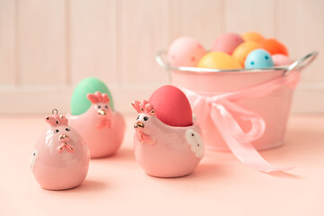 Fototapeta na wymiar Easter eggs and ceramic hen on pink wooden table. Easter celebration concept. Soft focus
