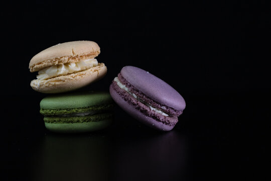 Colorful tasty macarons isolated on black background, french macarons dessert
