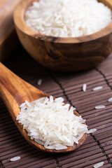 rice grains on a wooden spoon on the table close-up