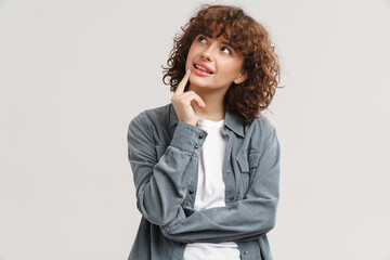 Young ginger woman in shirt thinking and looking upward