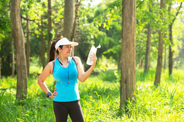 Healthy athletic woman running in the Nature park to be more healthy. Healthy and Lifestyle concept. On Green Nature background.