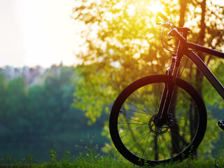 Bicycle on the river Bank at sunset . Active lifestyle concept, green park or forest
