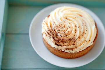 Buttercream and cinnamon cake on a blue tray