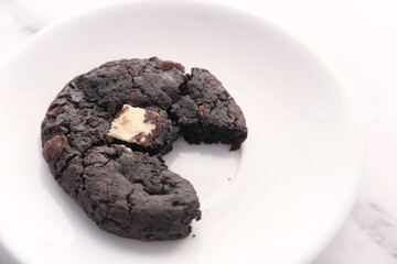  half eaten chocolate sweet cookies on plate 
