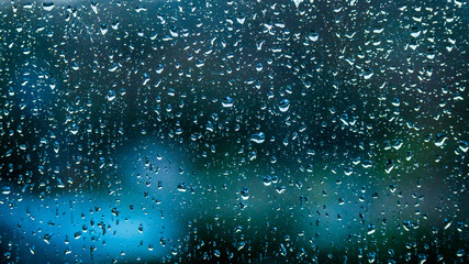  Rain drops on window glass on dark blue background