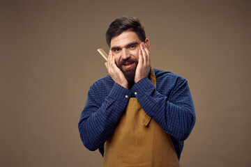Obraz premium bearded man in apron barbershop service beige background hair care