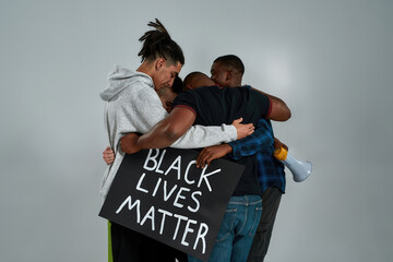 Rear view of young multiracial people hugging each other