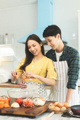 Portrait young couple in love helping to cook In a romantic atmosphere at home and looking at camera with smile face.