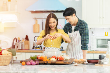 A couple breaks an egg to make a morning omelet at home. Romantic time For a newly married couple.