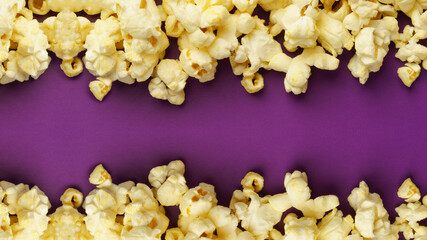 cooked popcorn on a violet background. Leisure concept