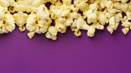 cooked popcorn on a violet background. Leisure concept