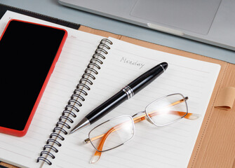 Opened agenda with handwritten MONDAY on a grey close up