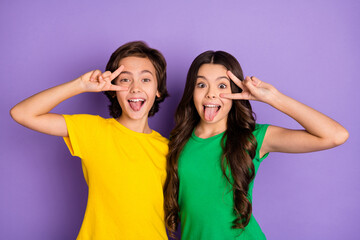 Fototapeta na wymiar Photo of two little boy and girl make funny face tongue out show v-sign isolated on purple color background