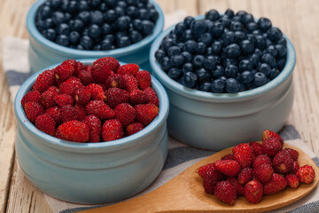 Blueberry and strawberry in ceramic bowls, organic food