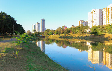 Late afternoon in the ecological park (Parque Ecológico) of Indaiatuba with lake reflecting the trees and buildings.