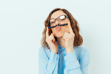 Portrait of carefree young business woman having fun holding pen like mustache
