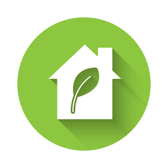 White Eco friendly house icon isolated with long shadow. Eco house with leaf. Green circle button. Vector