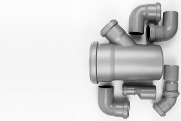 PVC plastic water pipes in gray color, insulated on a white background. The concept of installation, replacement of plastic pipes, plumbing. Top view. Flatlay. Copyspace.