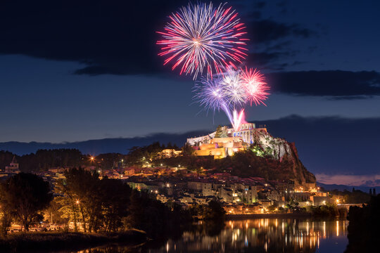 Sisteron with 14th of July fireworks (Bastille Day celebration) over the Citadel at twilight. Durance Valley, Alpes-de-Haute-Provence, France
