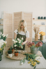 Flower shop. Girl florist makes a beautiful spring bouquet