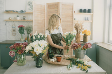 Flower shop. Girl florist makes a beautiful spring bouquet