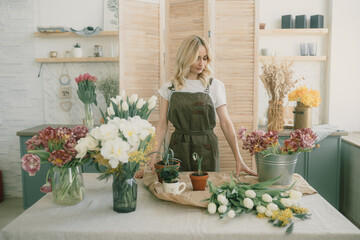 Flower shop. Girl florist makes a beautiful spring bouquet