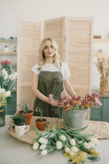 Flower shop. Girl florist makes a beautiful spring bouquet
